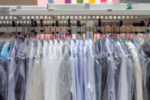dry cleaned garments on a revolving rack, in a dry cleaning store that received a energy use audit